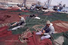 Image du Maroc Professionnelle de  Quelques ouvriers s'activent à réparer les filets de pêche sur un des quais au port d'Agadir, ville située au sud du Maroc, Vendredi 23 Août 2002. (Photo / Abdeljalil Bounhar)

 